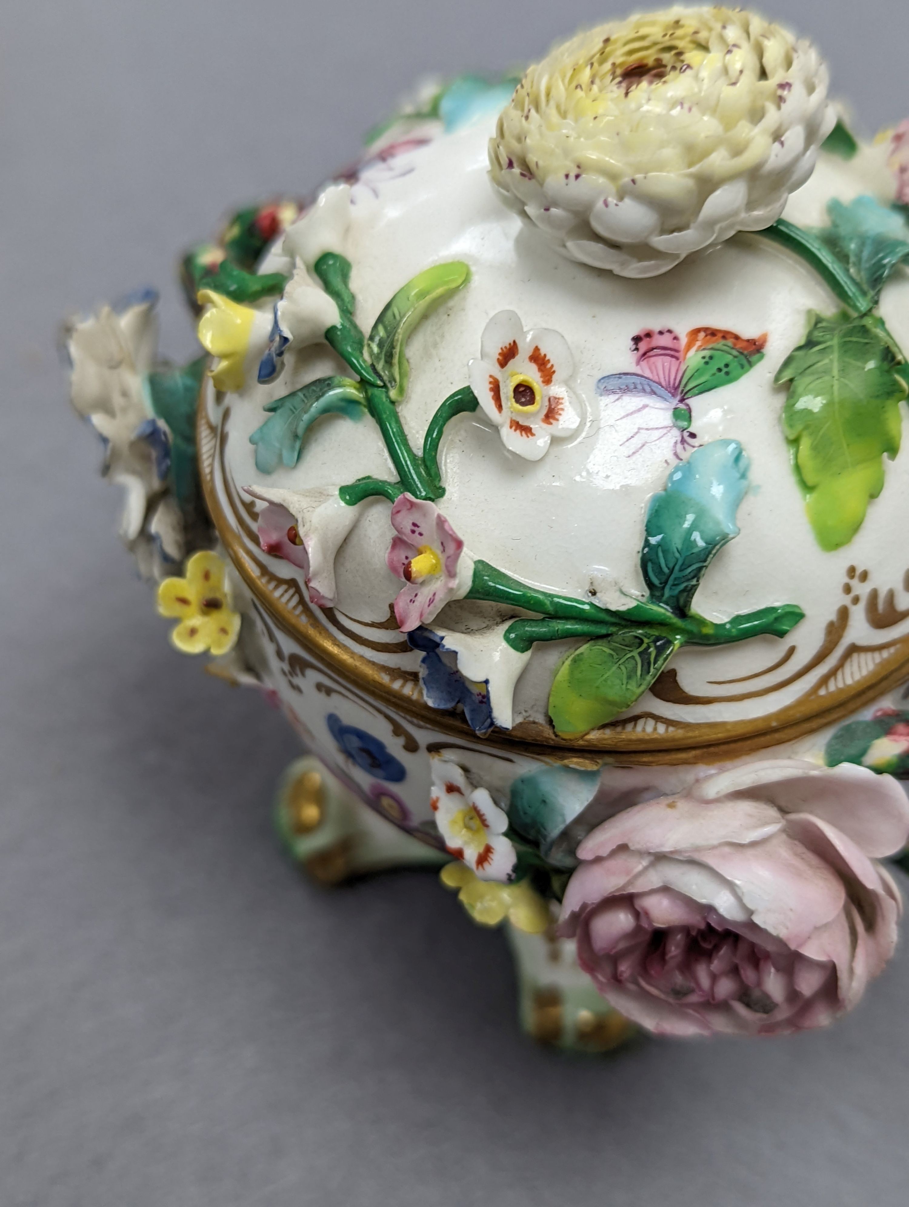 An 18th century Mennecy porcelain cup and cover, a Meissen style cup and cover, an English porcelain floral encrusted double inkwell and cover and a similar jar and cover